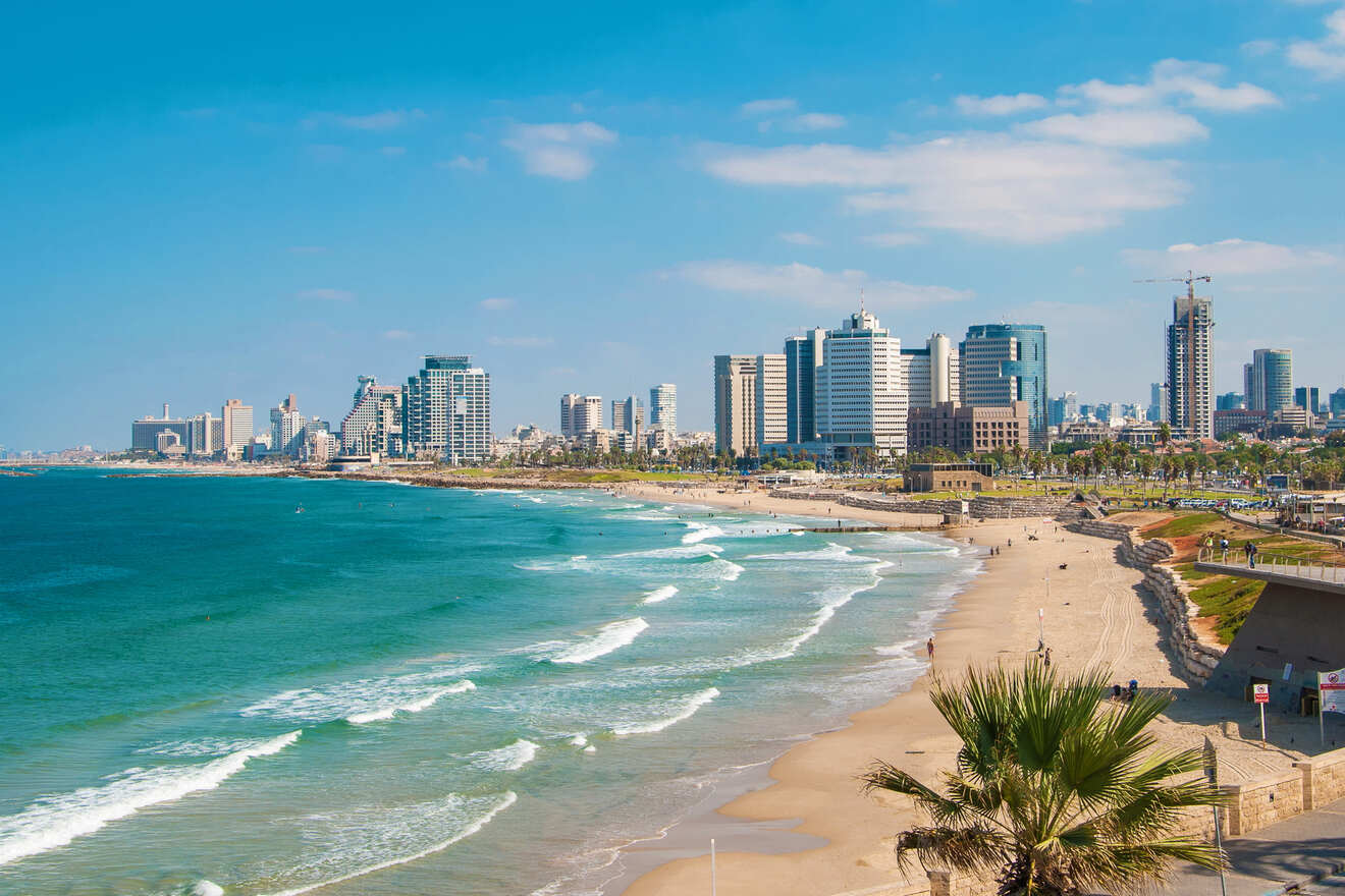 A serene coastal view of Tel Aviv’s skyline with sandy beaches and waves gently lapping at the shore